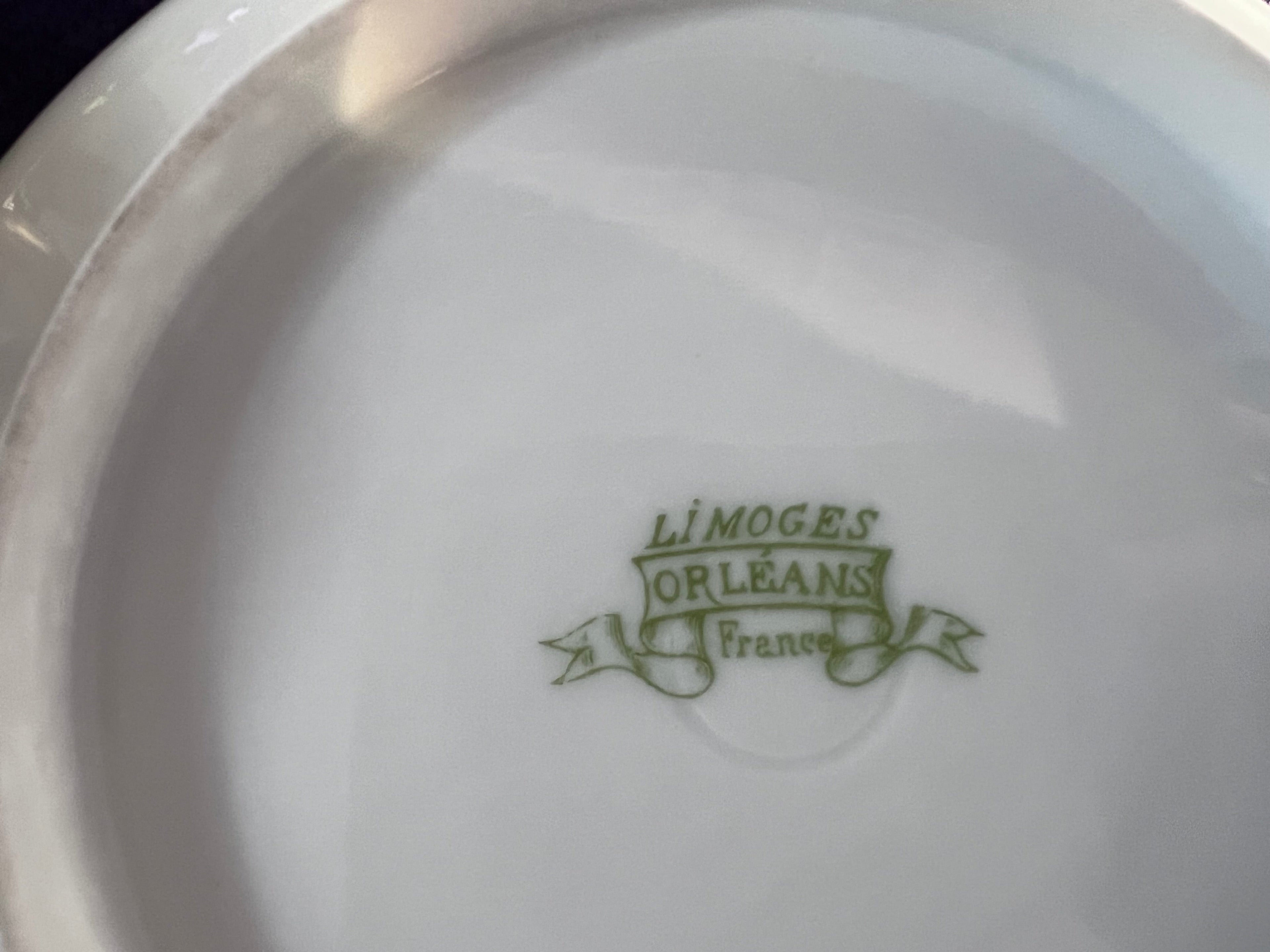 Close-up of a Limoges Orleans France logo on a white plate.