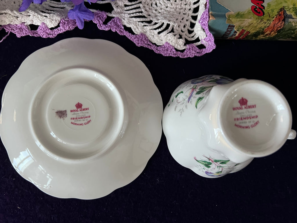 Two pieces of Royal Albert ceramicware on a dark surface with a crocheted doily in the background.